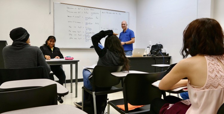 Professor John Boyles works with students and a language consultant in a field methods class.