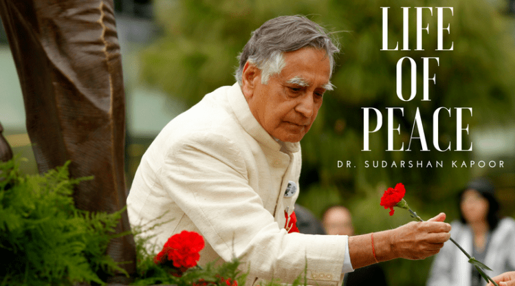 In this March 27, 2012 photo, Dr. Sudarshan Kapoor holds a red rose as he stands by the statue of Cesar Chavez in the Peace Garden at Fresno State.