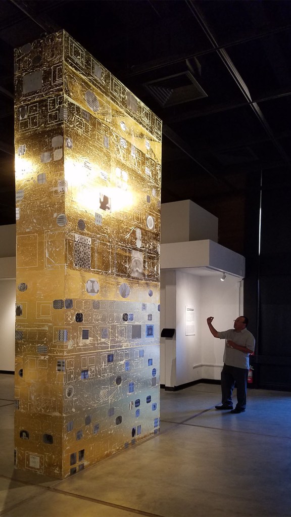 Martin Valencia, Art and Design Department Chair, takes a picture of the gold foil totem