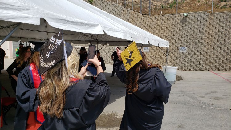 CAH students take photos of each other's mortarboards