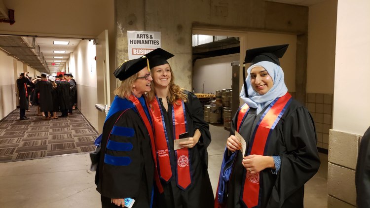 Dr. Kathleen Godfrey, chair of the Department of English, jokes with students as they line up for the CAH Convocation.
