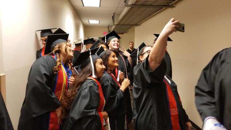 English students take selfies as they line up for CAH Convocation.