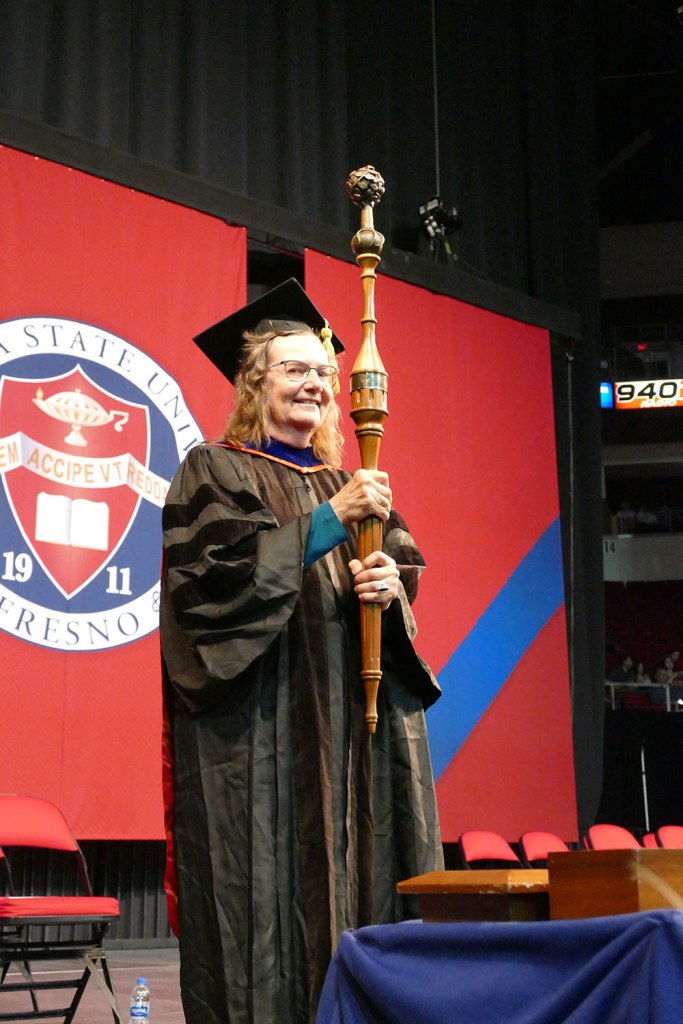 Bearing Fresno State’s ceremonial mace, Chris Henson leads the faculty procession into the Save Mart Center for the University’s 108th Commencement. (Photo: Benjamin Kirk/Fresno State)