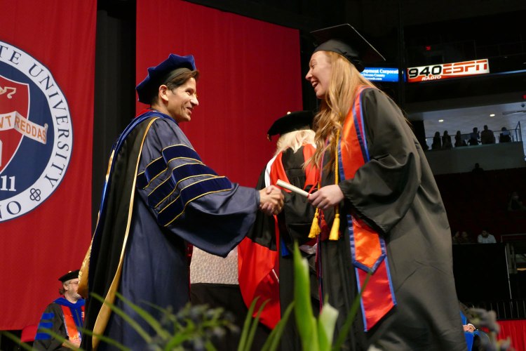 CAH graduate shakes Dr. Saúl Jiménez-Sandoval as she walks across the stage.