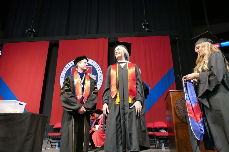 Alyssa Espinola receives her Master of Arts hood in Communication.
