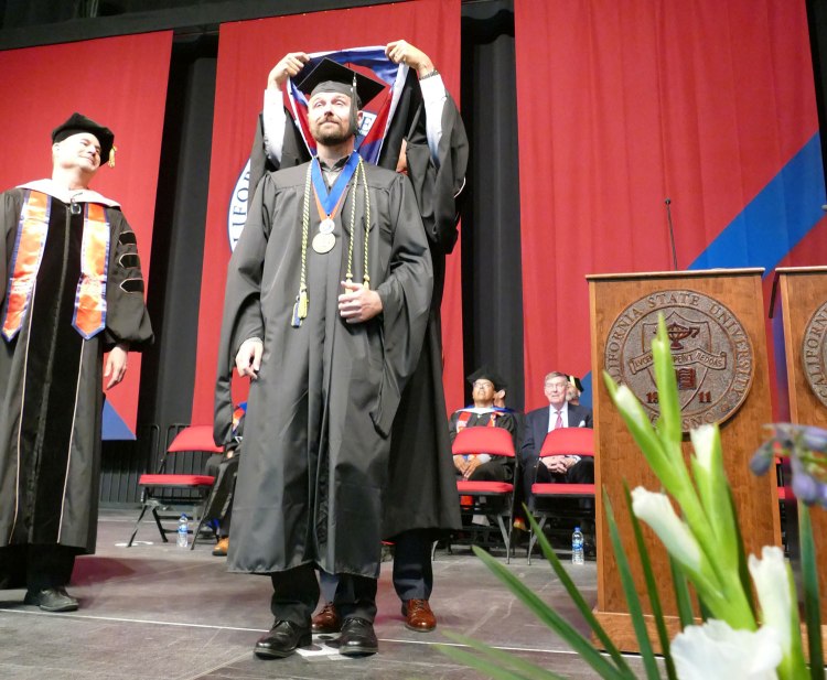 Dean's Medalist Mason Lamb receives his hood for the Master of Arts Degree in Music Performance.