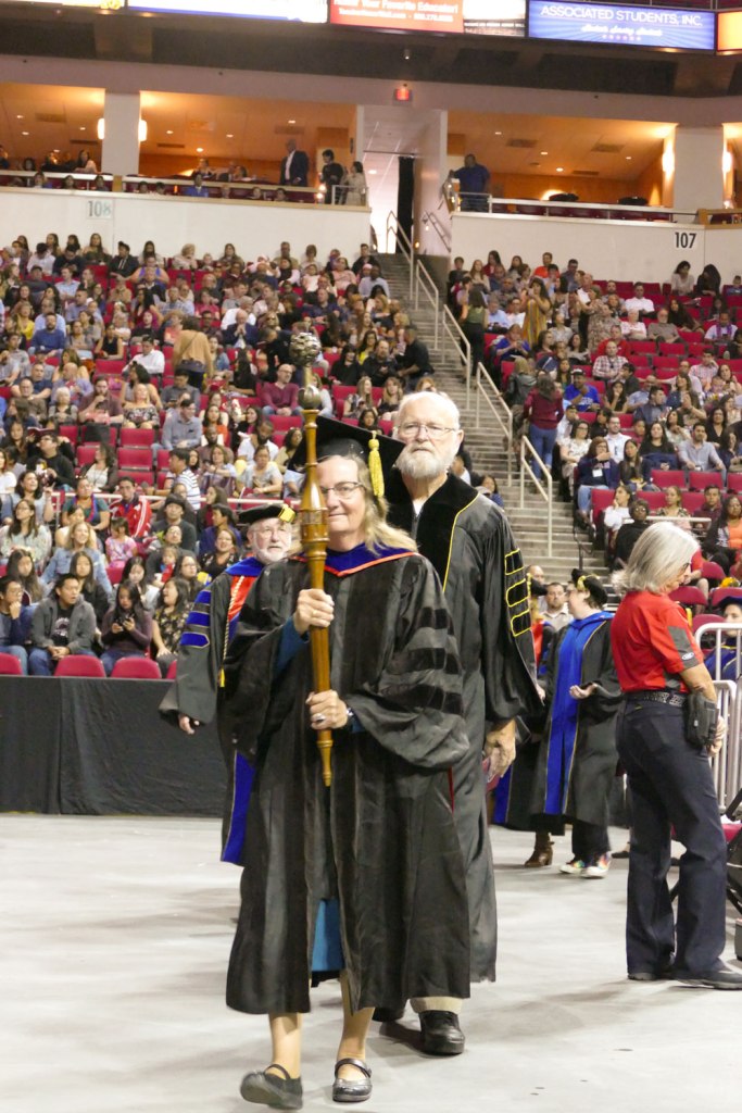 Bearing Fresno State’s ceremonial mace, Chris Henson leads the faculty procession into the Save Mart Center for the University’s 108th Commencement.