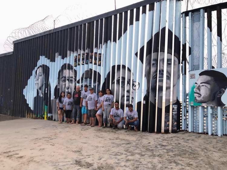 Lizbeth De La Cruz Santana and a group of volunteers pose at the Playas de Tijuana Mural Project