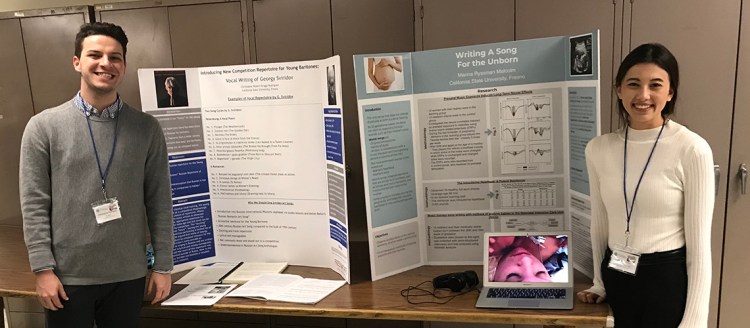 Two music students standing in front of their presentations