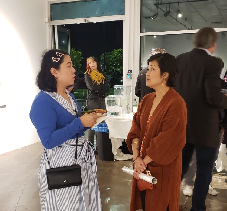 Artist Phung Huynh (right) talks to a guest during the Arthop opening of her “Resistance Aunties" exhibition.