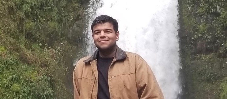 Olegario Tapia in front of a waterfall