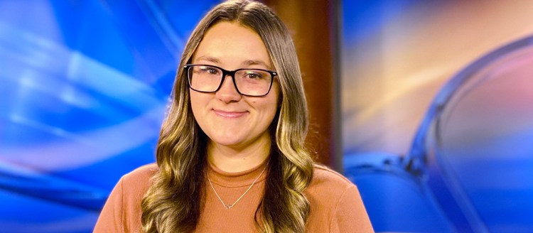 Brittney Steele sits in a television studio set.