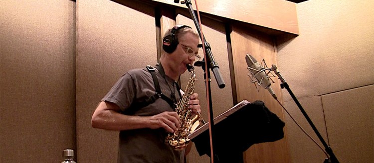Fresno State music theory and composition professor Benjamin Boone plays his alto saxophone in the studio while recording his album "The Poets are Gathering."