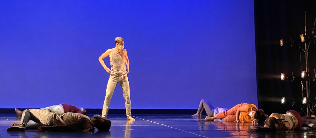 masked dancers on a stage.