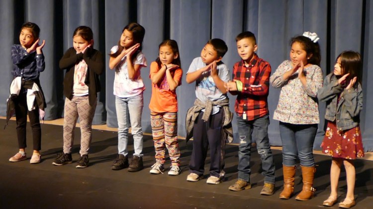 Young students perform on stage during Peach Blossom