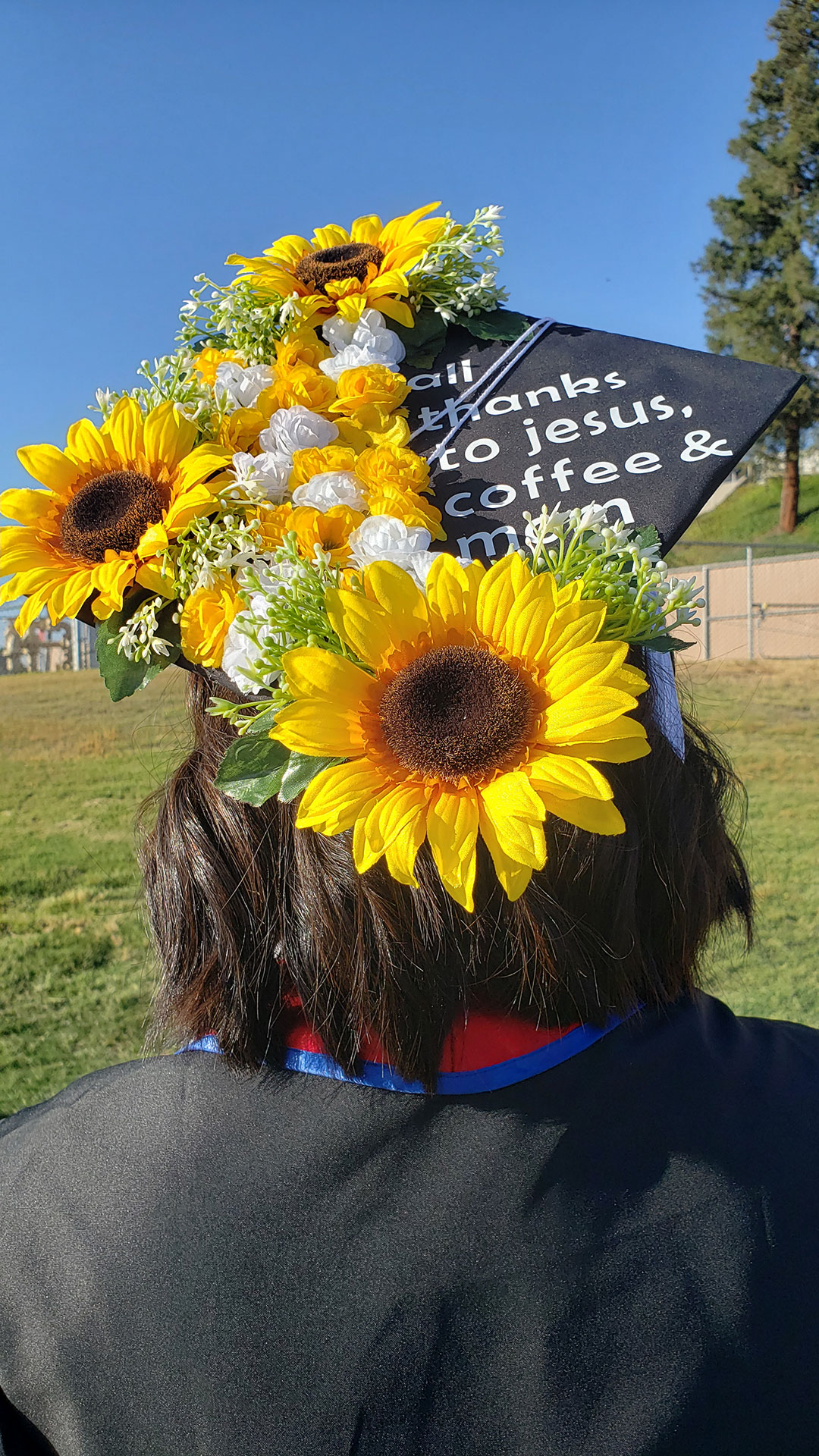Grad cap decorated in flowers. "All thanks to jesus, coffee & mom"