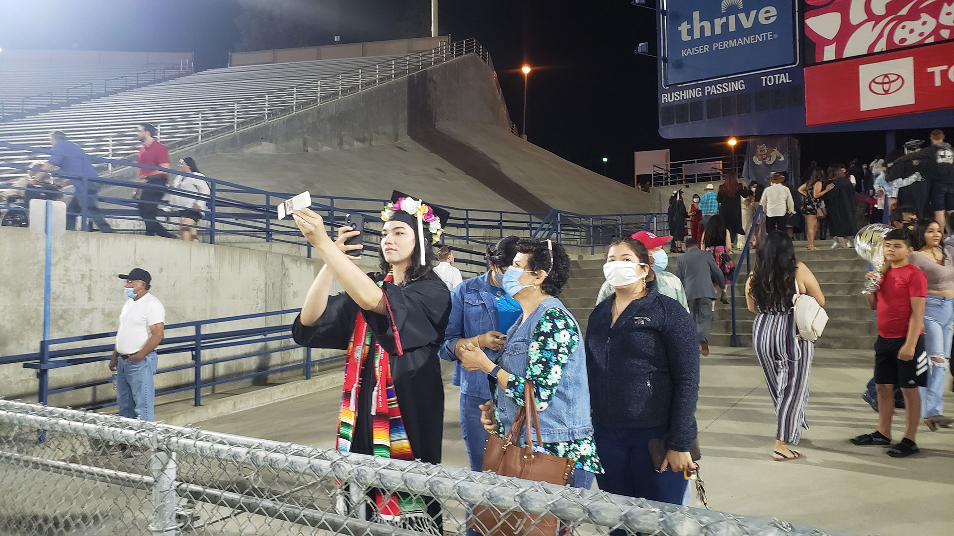 A student takes a selfie with loved ones after commencement.