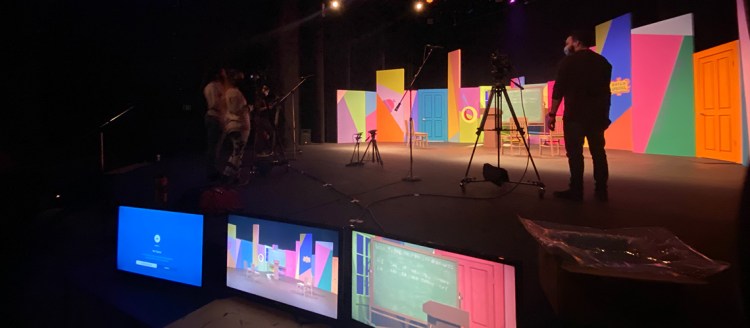 Monitors and camera's on a colorful stage set.
