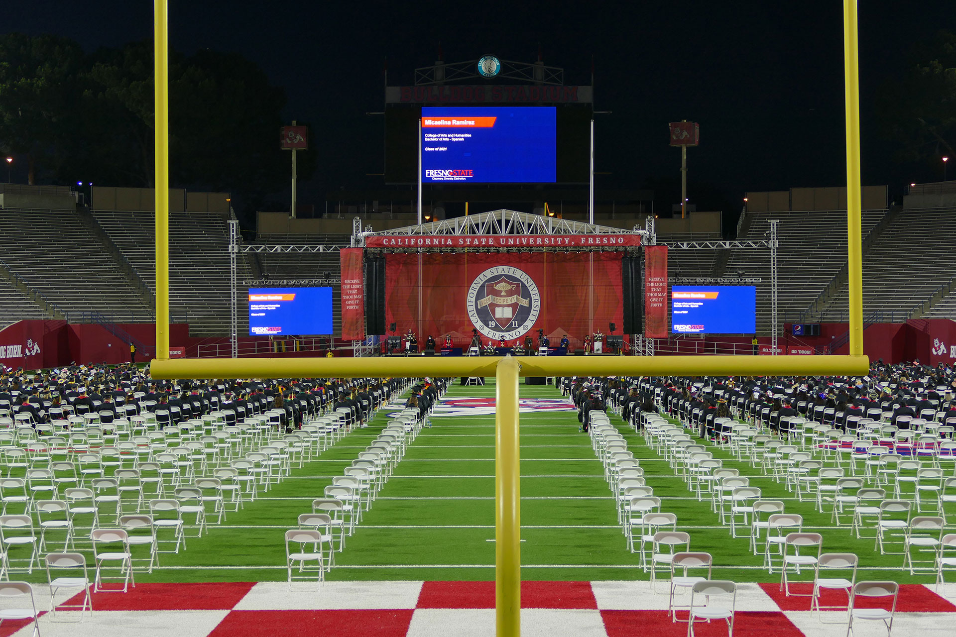 A view of the commencement ceremony through the football goal posts.