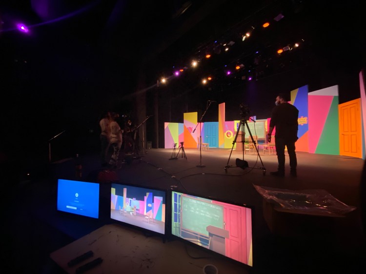Monitors and camera's on a colorful stage set.
