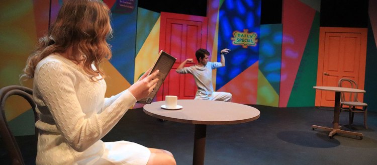 Woman holds a book with a cup of coffee while looking at a young man in a weird flex pose. All in front of an absurdly colorful background.