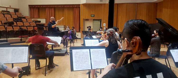 Conductor Thomas Loewenheim leads the 2021 string orchestra during rehearsal