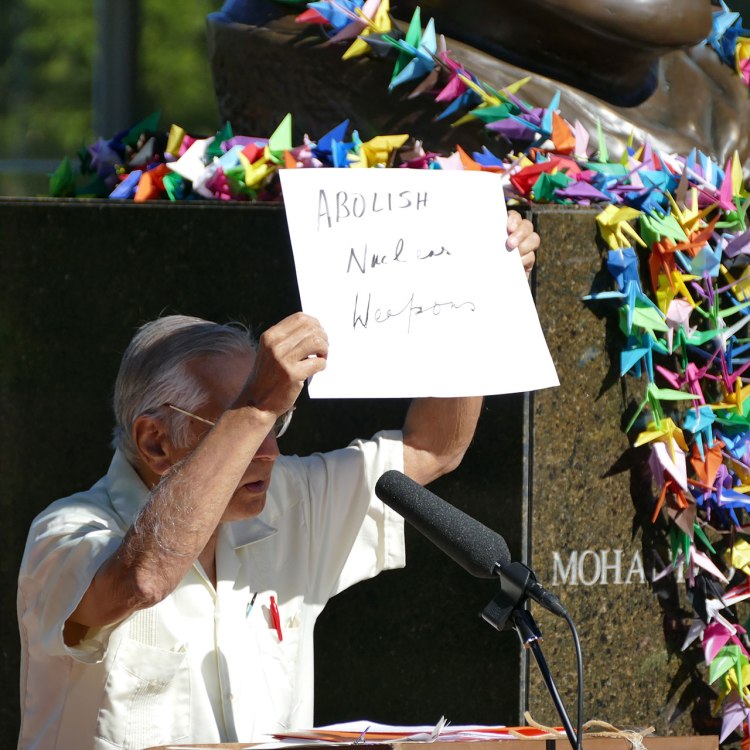 Dr. Kapoor holds a hand-written sign which says "Abolish Nuclear Weapons"