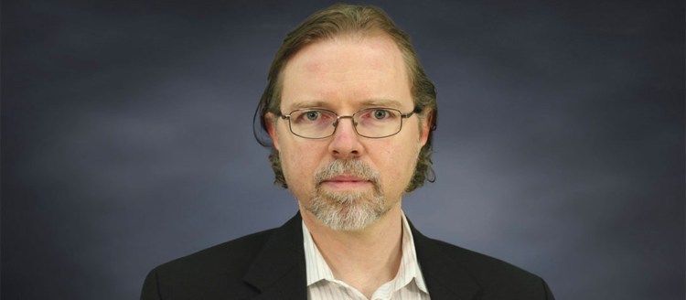Sean Fulop poses with a grey background.