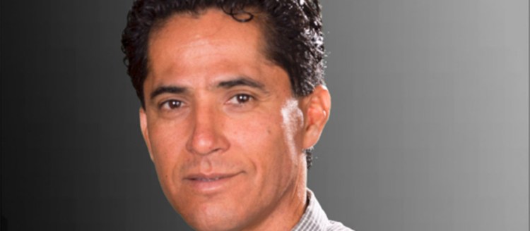 Adan Avalos poses with a grey/black backdrop