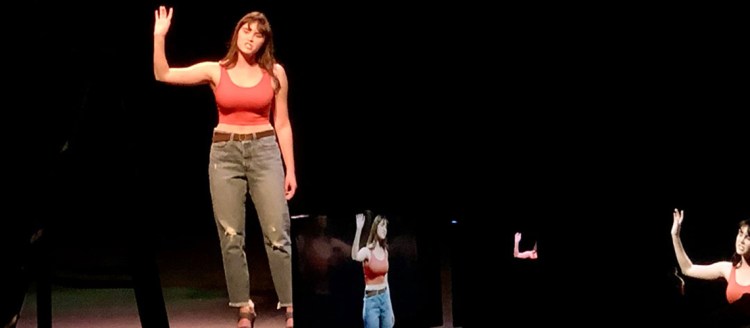 Cassidy is on stage, and several reflections of herself can be seen in the mirrors before her.