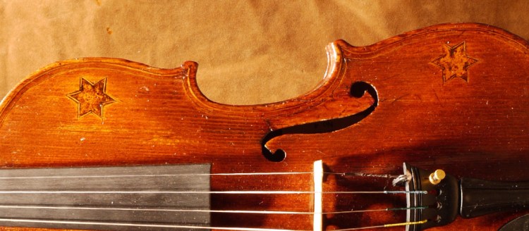 Yaacov Zimermann worked in Warsaw and had many clients Jews and Christians. He was known to support young violinists such as Michel Swalbe (see former violin) and Ida Haendle, the child prodigy who turned a world known virtuoso. This hand-made violin is outstanding because it is unusually decorated by five Stars of David, four on the upper deck and one on the back. The decorations were made with glue mixed with black powder, usually made to order.