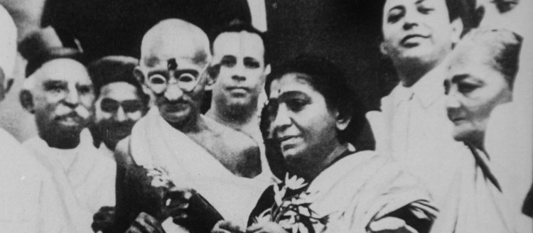A black and white image of M.K. Gandhi and his entourage prepare to board a ship.