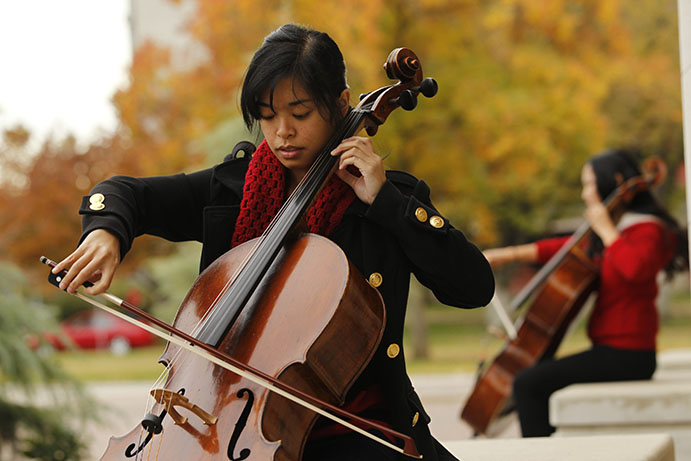 Musicians play the cello outside of the music building.