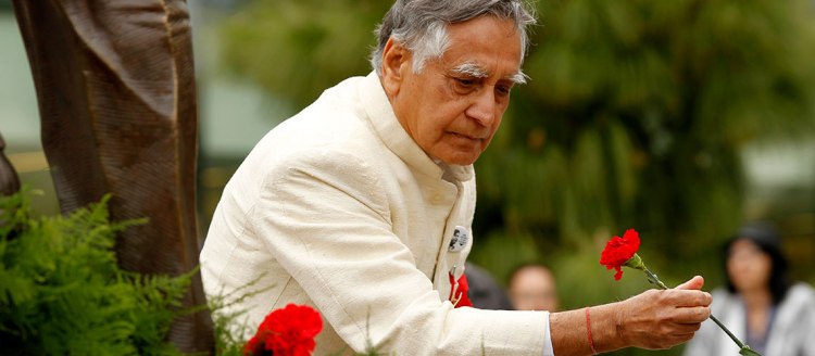 Dr. Sudarshan Kapoor places a rose during an event at the Fresno State Peace Garden