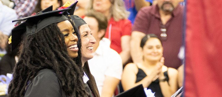 2022 Graduate President's Medalist stands during the College of Arts and Humanities commencement ceremony.