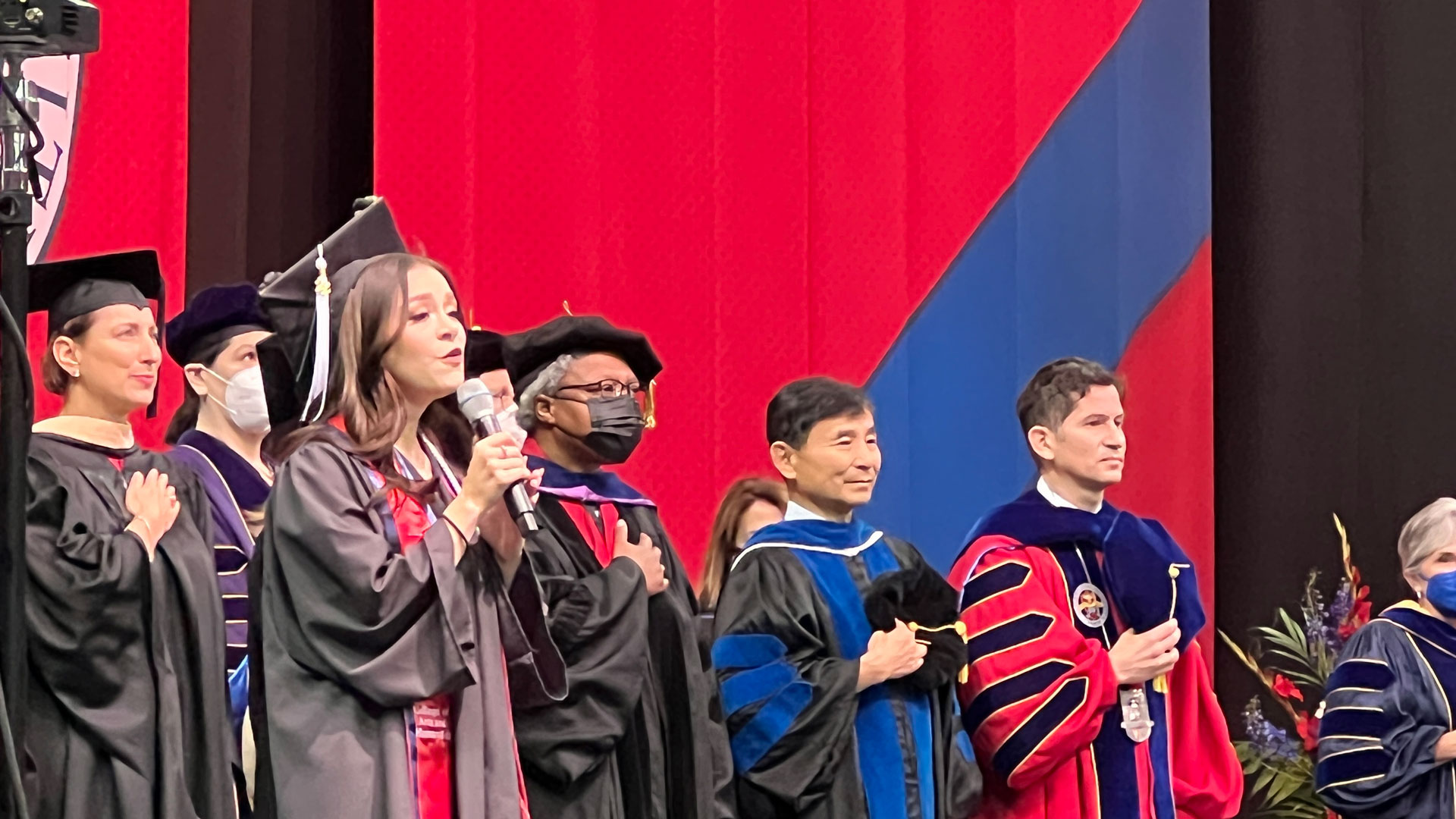 Zoey Turney sings the National Anthem on stage.
