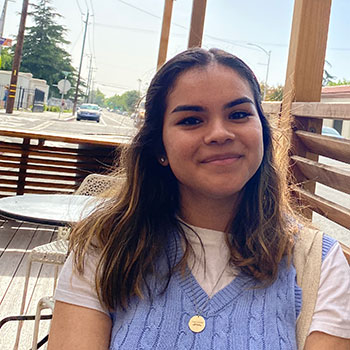 Nayeli Guerrero sits at a roadside restaurant dining area.