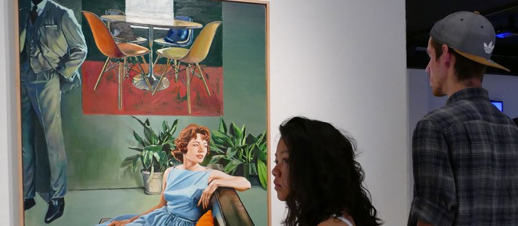 Students look at a large painting of a retro living room with a man and woman and a 1960s vibe
