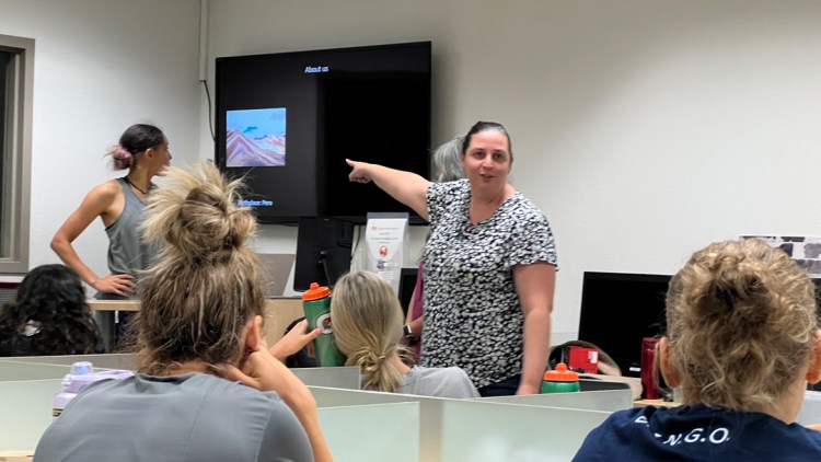 Dr. Jaydene Elvin points at the screen while instructing the Fresno State Women's Basketball Team.