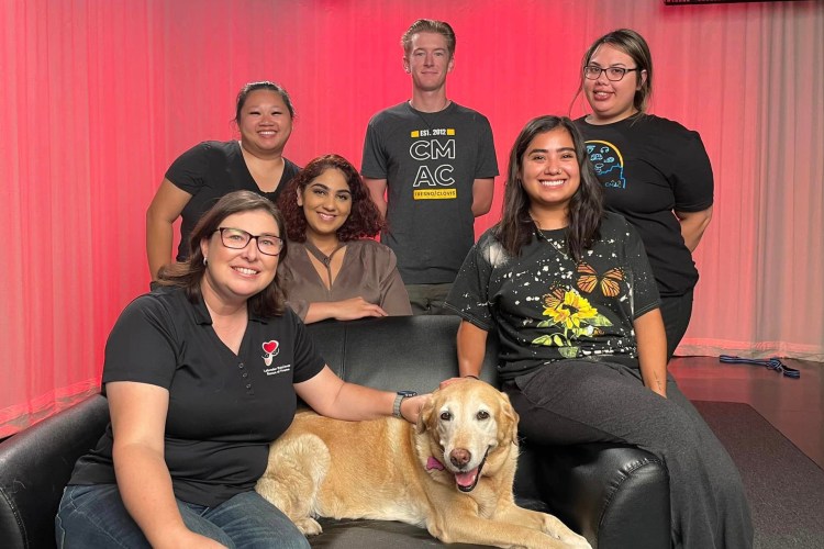 Public Relations students at CMAC during video PSA filming with tan Labrador Retriever