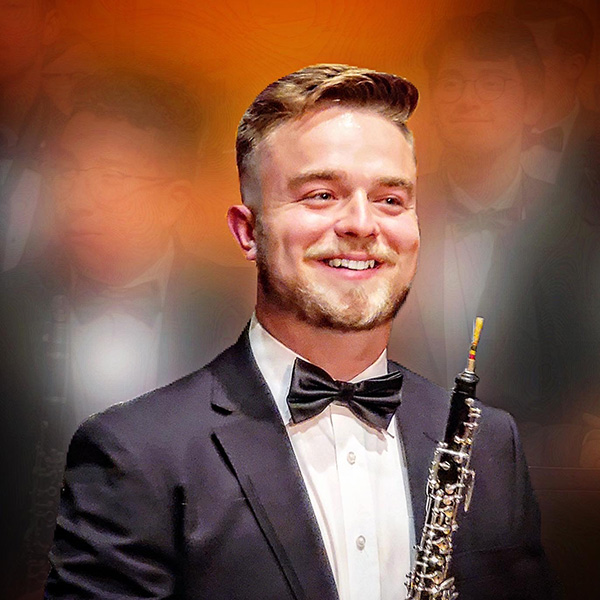 Cameron Baber in a tuxedo with an oboe.