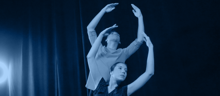 Two dancers, man and women, in a blue toned photo.
