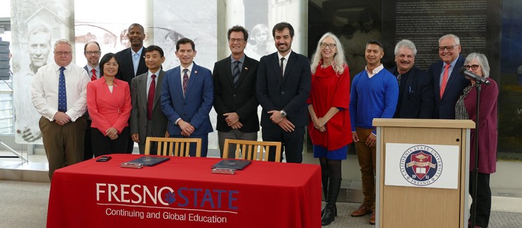 Fresno State President Saúl Jiménez-Sandoval and Dr. Michael Baum, executive council for the Luso-American Development Foundation, stand with other Fresno State and FLAD colleagues in a group photo.