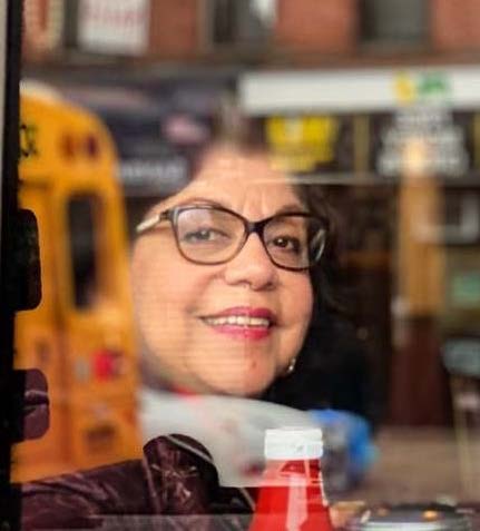 Chavez sitting inside a diner as the windows reflect the passing traffic.
