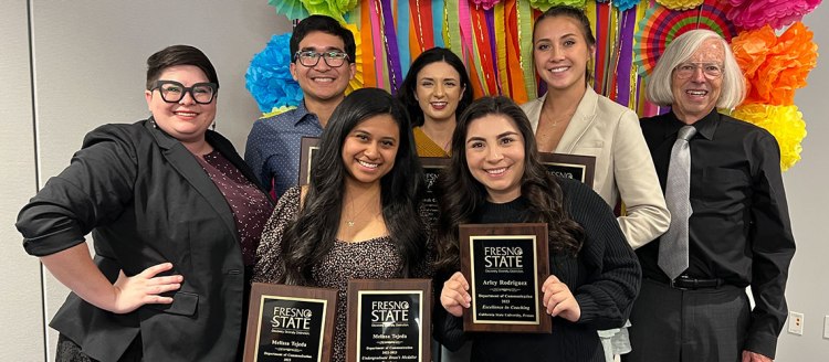 Graduating seniors show off their awards alongside coaches Douglas Fraleigh and Natalie Meaney Cavallero.