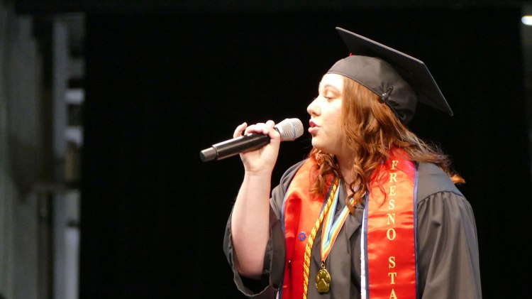 Soprano and Music Department graduate Aunika Bull sings the national anthem in full regalia.