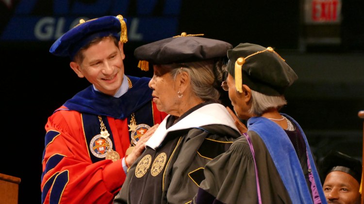 Just hooded, President Saúl Jiménez-Sandoval smiles at Dr. Holly Blossom Wyatt.