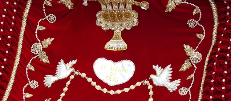 A Queen's cape, red with white and gold accents