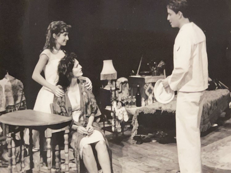 A black and white image Jacquline Antaramian and Jodi Baker as they look at actor Daniel Swartz in a sailor outfit on stage.