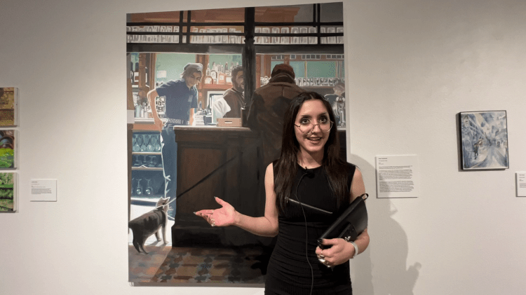 Angel Lesnikowski stands in front of her painting “The Saracen's Head" depicting a pub in London using the realist style.